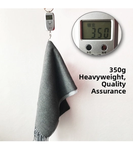 Detail shot of heavy 350g dark gray scarf being weighed to show premium material thickness