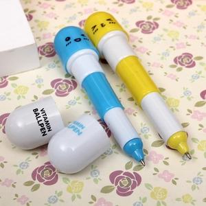 Detailed macro view of yellow and blue pill-shaped vitamin ballpoint pens on floral paper
