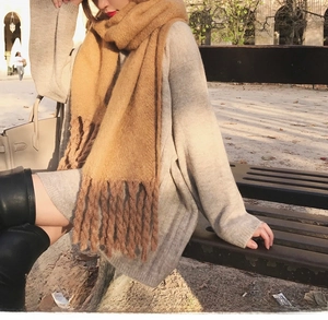 Detail shot of camel mohair knit scarf with long tassels paired with gray wool sweater