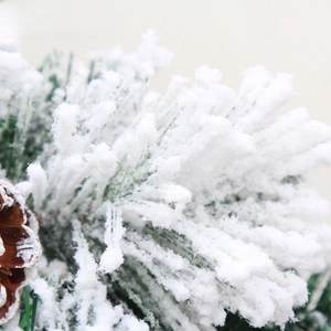 Macro shot of snowy flocked pine needles and natural brown pine cones for Christmas decor