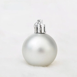 Close-up of matte silver Christmas ball ornament on white faux fur background decoration