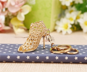 Macro detail of golden metal high heel keychain pendant with mesh hollow-out design