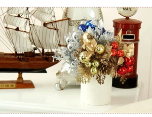 Detailed view of colorful Christmas berry picks in gold and silver within a white vase