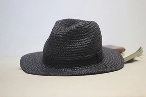 Detail of black raffia jazz hat featuring classic straw weave and elegant ribbon