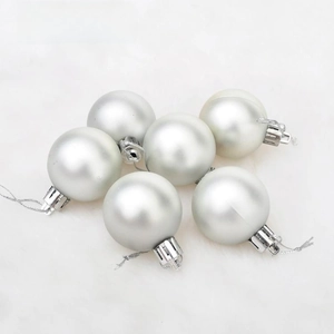 Detail of matte silver Christmas balls with hanging loops on white plush background