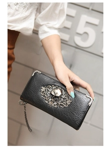 Detail of black gothic skull wallet with ornate silver metal hardware and chain