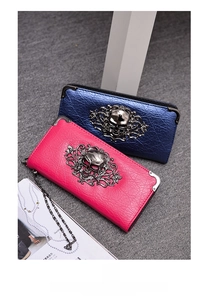 Detail of punk style skull wallet featuring gothic floral patterns and metal chain