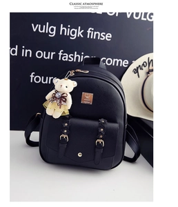 Detailansicht eines schwarzen PU-Leder-Rucksacks mit Goldschnallen und Bärenanhänger