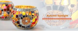 Close-up of handmade mosaic glass candle holder with vibrant orange and purple shards