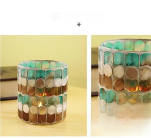 Detail of mosaic shell glass candle holder with glowing warm tea light inside