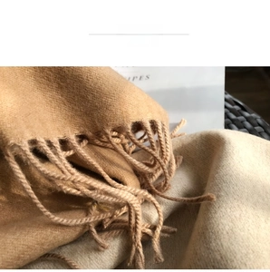 Close-up of soft camel cashmere-like scarf showing fine brushed texture and tassel detail