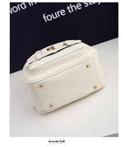 Nahaufnahme des beigen PU-Lederrucksacks mit goldenen Bodenstollen und Texturdetail