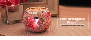 Close-up of pink mosaic glass candle holder with handmade star pattern and orchid