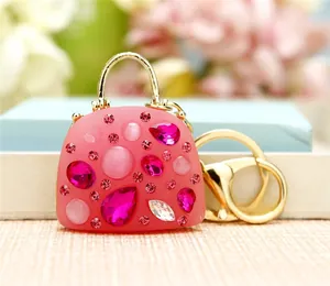Macro shot of pink mini handbag keychain with sparkling rhinestones and gold hardware