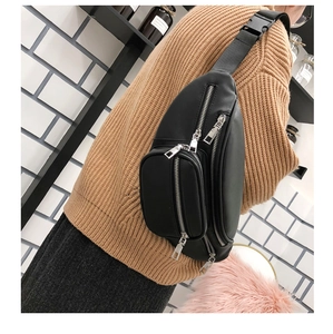 Close-up of black PU leather waist bag featuring multiple silver zippers and adjustable strap