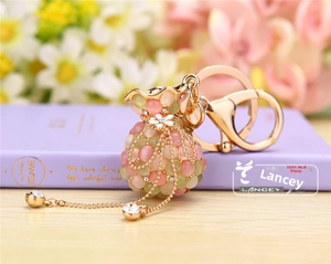 Porte-clés pochette porte-bonheur rose et vert avec perles œil de chat et pompon