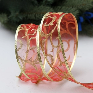 Close-up of red organza Christmas ribbon with gold glitter scrolls and wired edges
