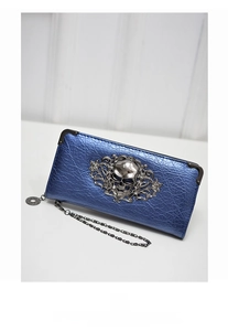 Close-up of blue metallic leather purse with vintage crackle finish and silver skull emblem