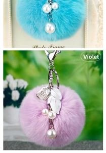 Détail de pompons en peluche bleu et violet avec glands de perles et breloque feuille