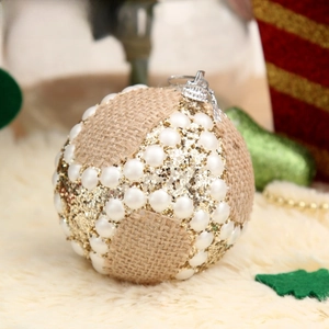 Detail of Christmas ornament with burlap fabric, faux pearls, and gold sequins texture