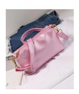 Pink pearlescent jelly crossbody bag with gold hardware and adjustable strap on white fabric