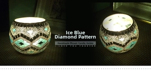 Macro detail of handmade ice blue and gold mosaic glass candle holder with glowing light