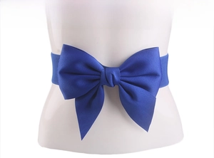 Detail of a blue elastic waist belt featuring a large satin bow for women's dresses