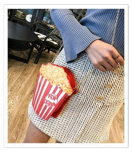 Macro detail of popcorn bucket crossbody bag showing red stripes and 3D textured popcorn