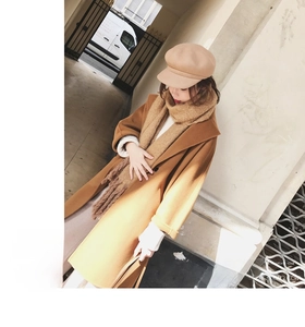 Outdoor shot of warm camel wool coat with matching mohair scarf and stylish baker boy hat