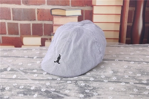 Close-up of blue and white striped flat cap with black rabbit silhouette embroidery