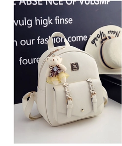 Nahaufnahme von beigem PU-Lederrucksack mit Bärenanhänger und floralen Trägern