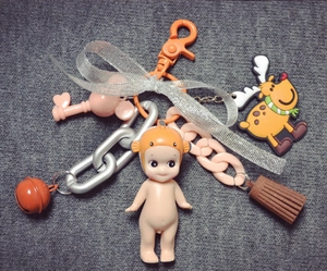 Detail of keychain featuring Sonny Angel doll, reindeer charm, bell, and brown tassel
