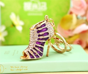 Detailed close-up of high heel keychain with purple enamel and sparkling white rhinestones