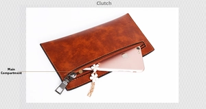 Macro detail of brown oil wax leather clutch showing main compartment with smartphone storage