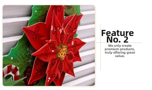 Detail of a 3D paper Christmas wreath with red poinsettia and glittery accents