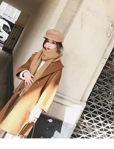 Detail of wool coat and mohair scarf with fringes in warm camel tones for winter