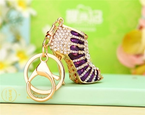 Macro shot of purple rhinestone high heel keychain with gold-plated ring and lobster clasp