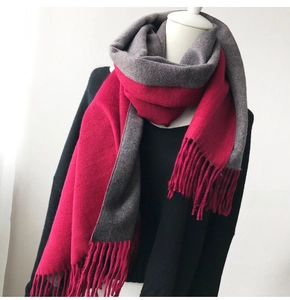 Detail of soft thick scarf with grey and fuchsia color blocks and fringe ends