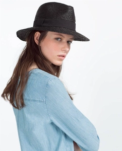 Detail of the woven raffia texture and black satin ribbon bow on this elegant fedora hat