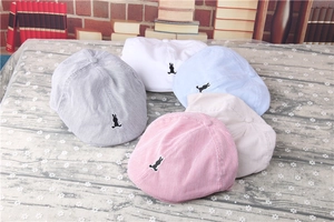 Detail of baby striped berets with black rabbit embroidery in multiple colors