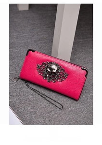 Detailed texture of rose red lychee leather wallet featuring a punk metal skull emblem