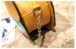 Macro detail of high-quality orange leather texture with golden zipper and metal chain