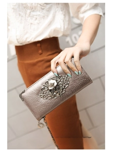 Close-up of silver skull long wallet with gothic floral relief and chain detail