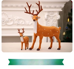 Detail view of two lifelike Christmas reindeer statues on a white festive fireplace