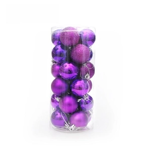 Détail de 24 boules de Noël violettes brillantes, mates et pailletées dans un tube clair