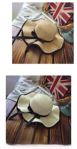 Detail of wide brim straw hats featuring contrast black ribbon bows and piping decor