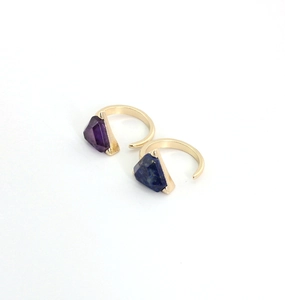 Detail view of gold adjustable rings featuring faceted amethyst and lapis lazuli stones