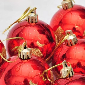Detail of red mirror Christmas balls with golden glitter patterns and hanging strings