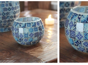 Close-up of blue and white mosaic glass candle holder with intricate floral patterns