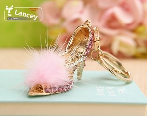 Detailed close-up of a pink rhinestone high heel keychain with a soft pom pom detail